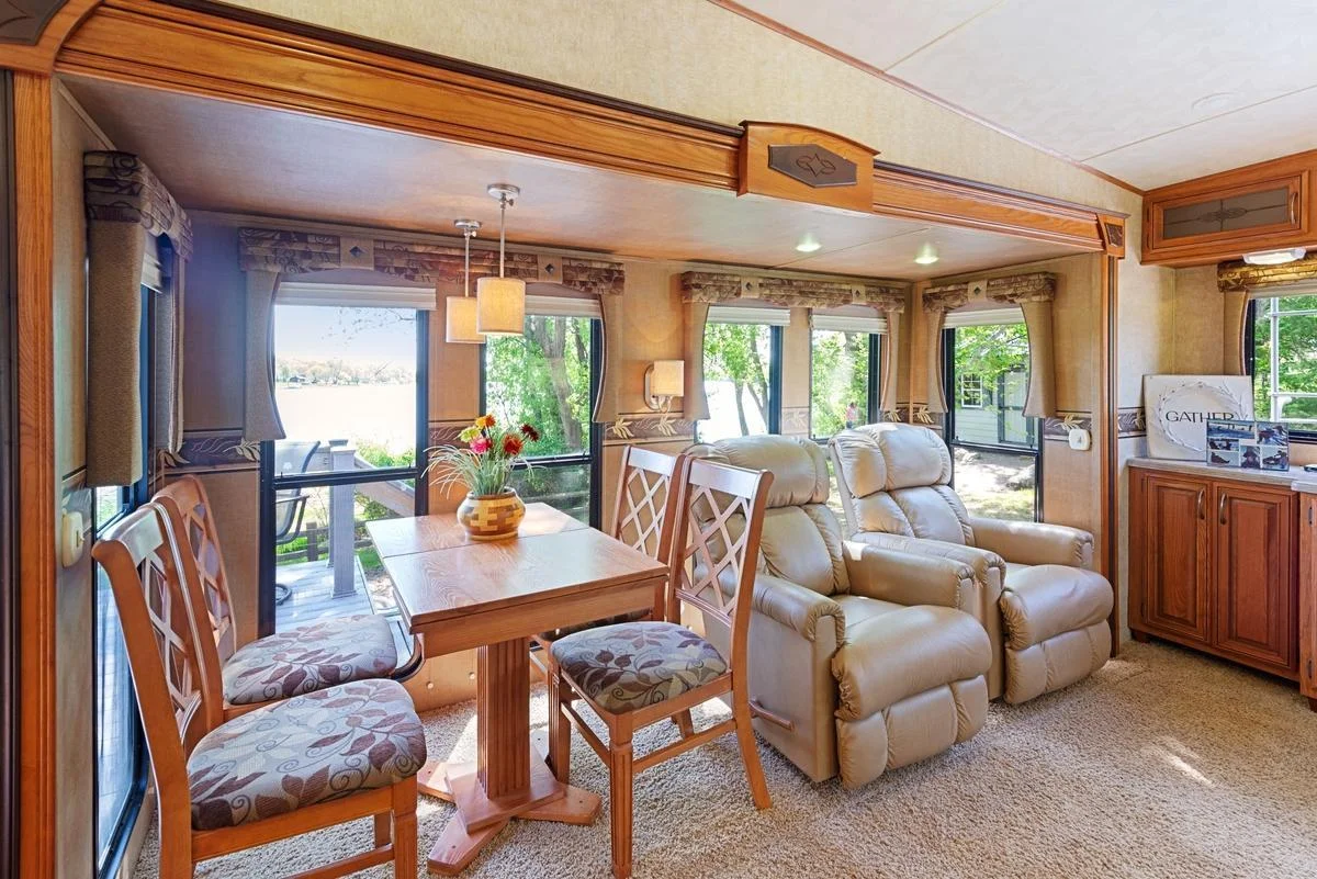 The lakeside dining and living room area offers a front-row seat to nature with expansive windows that frame picturesque lake views and fill the space with natural light.