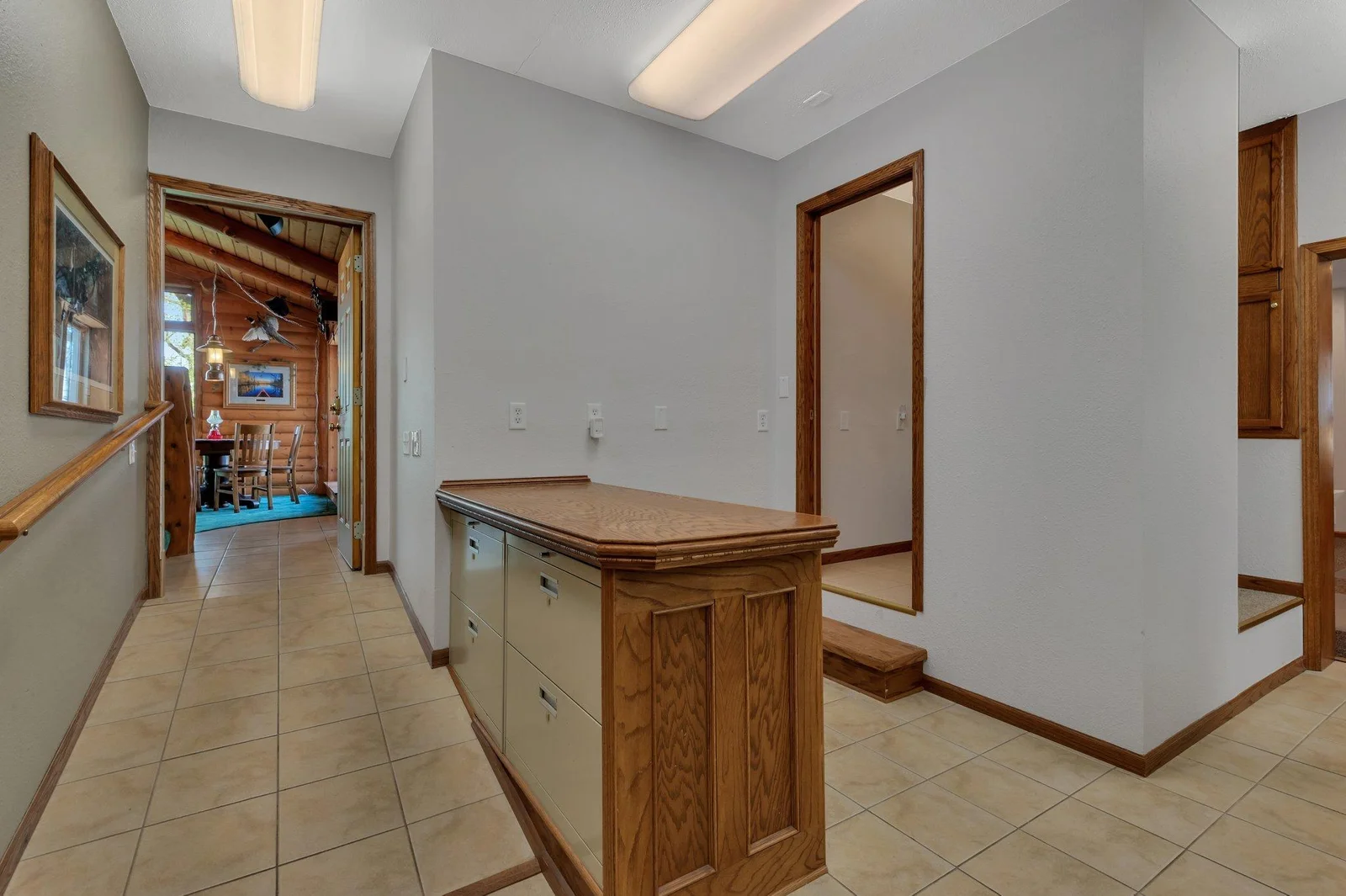 Reception desk at the home office. Main floor half bath located behind the reception area. Tiled hall leads to the Great Room.