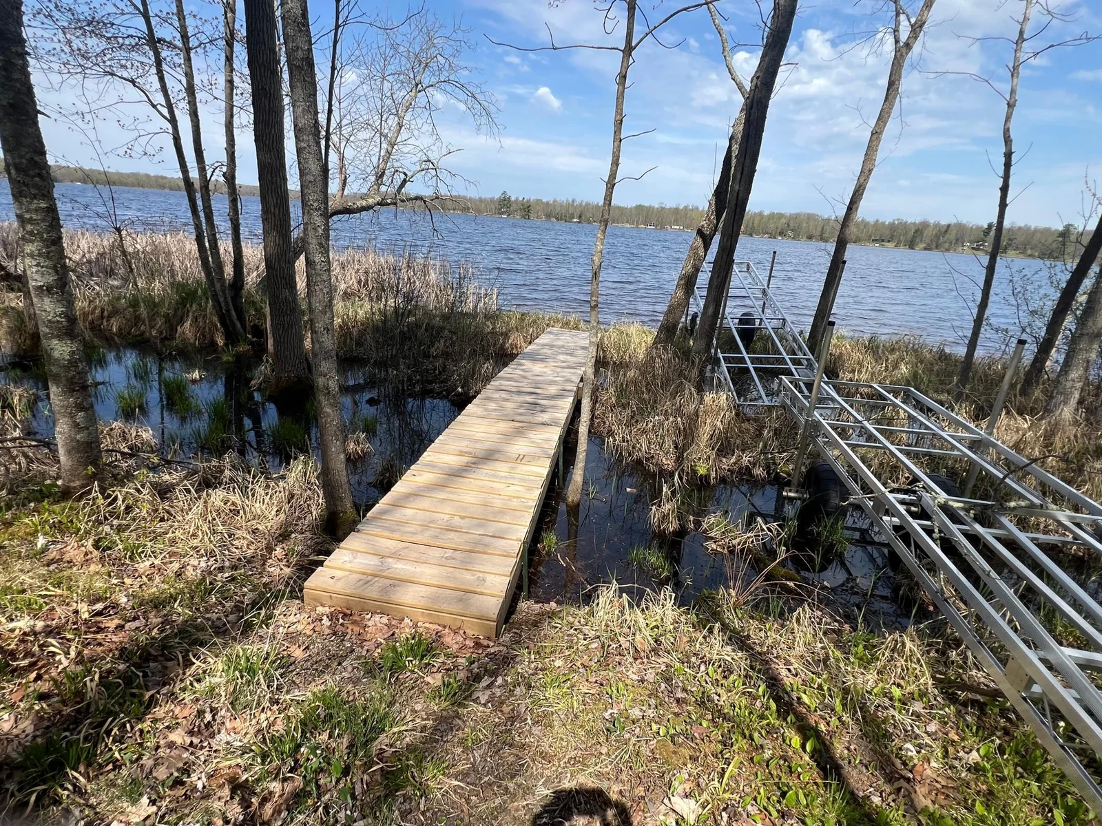 THERE IS A SHORT BOARDWALK THAT SPANS A SMALL WETLAND AREA, LEADING TO THE LAKE FRONTAGE.