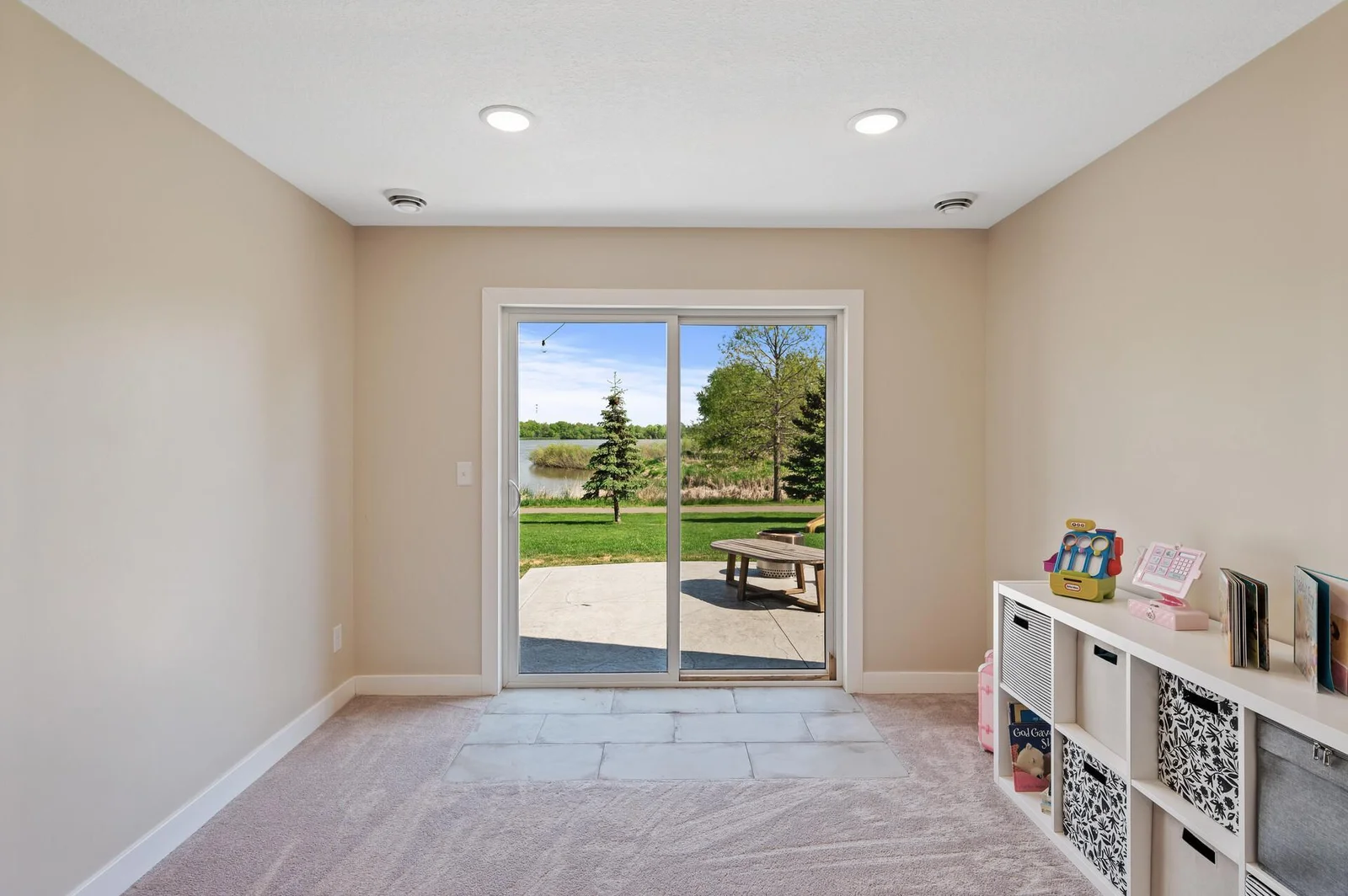 Walk out to green space with in-ground sprinkler system and stamped, concrete patio.