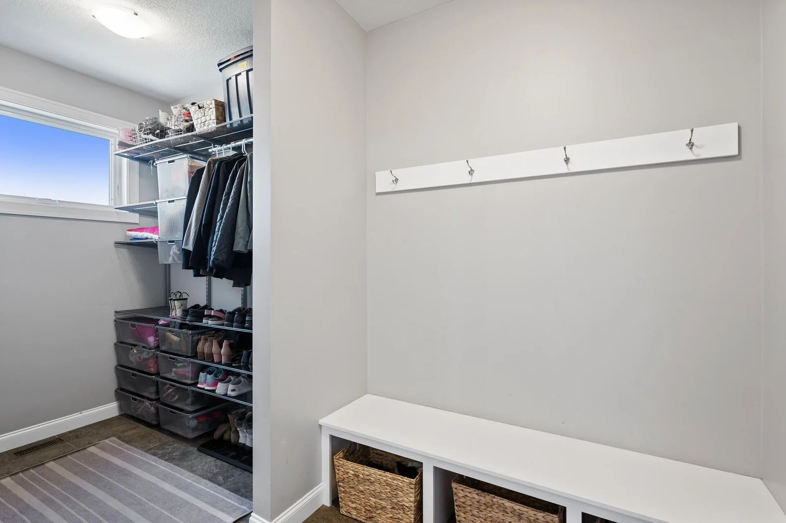 Garage entry with built-in seated bench and custom closet for kids and adults.