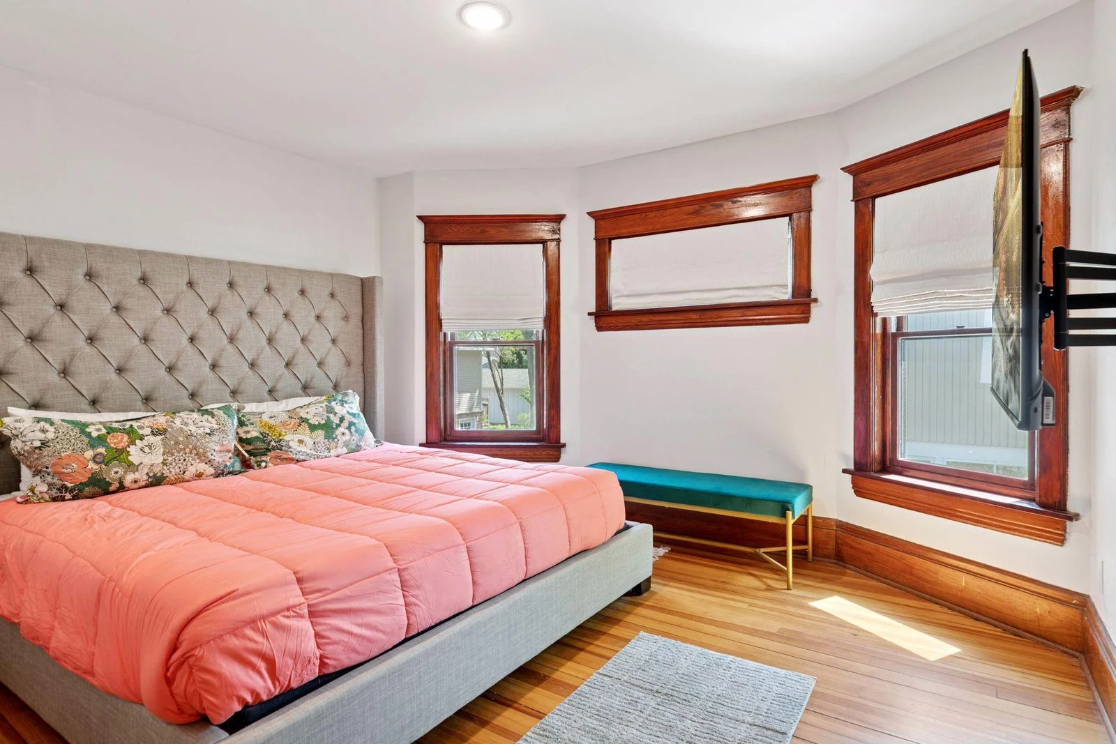 The sun-catching Victorian window ensemble in this bedrooms frames the space gracefully, showcasing timeless craftmanship.