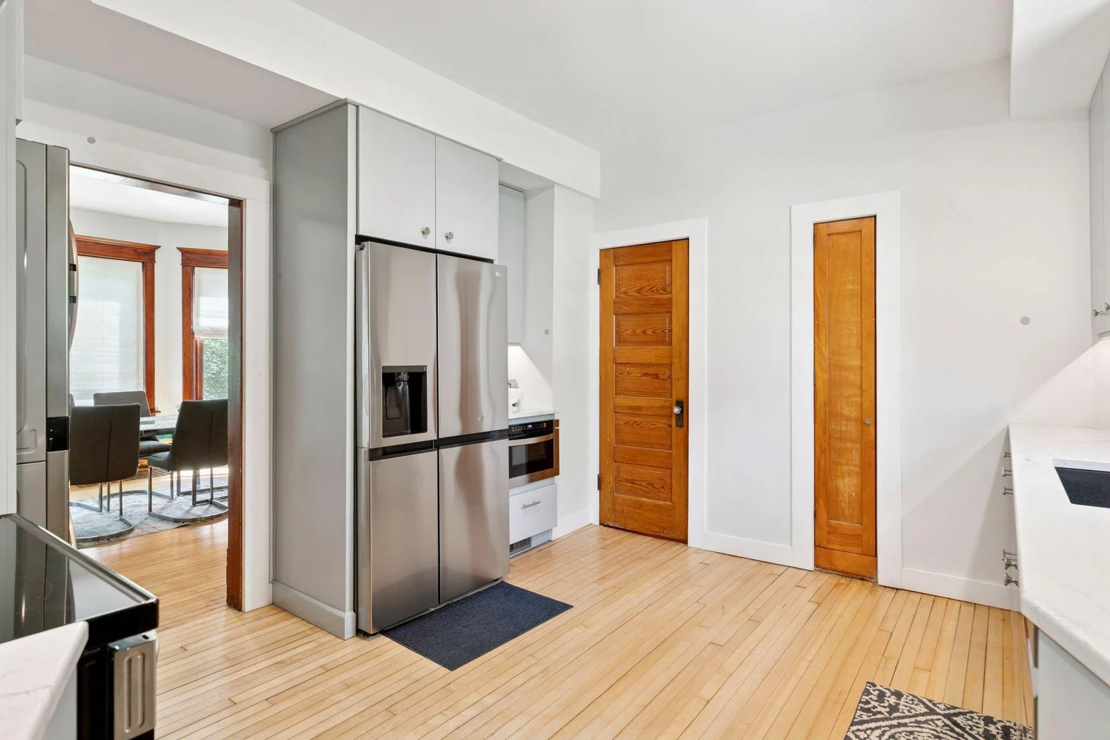 Immediately to the right of the full size refrigerator is a built-in microwave, and to the right of that is a door leading to the classic walkthrough pantry that leads back to the foyer.