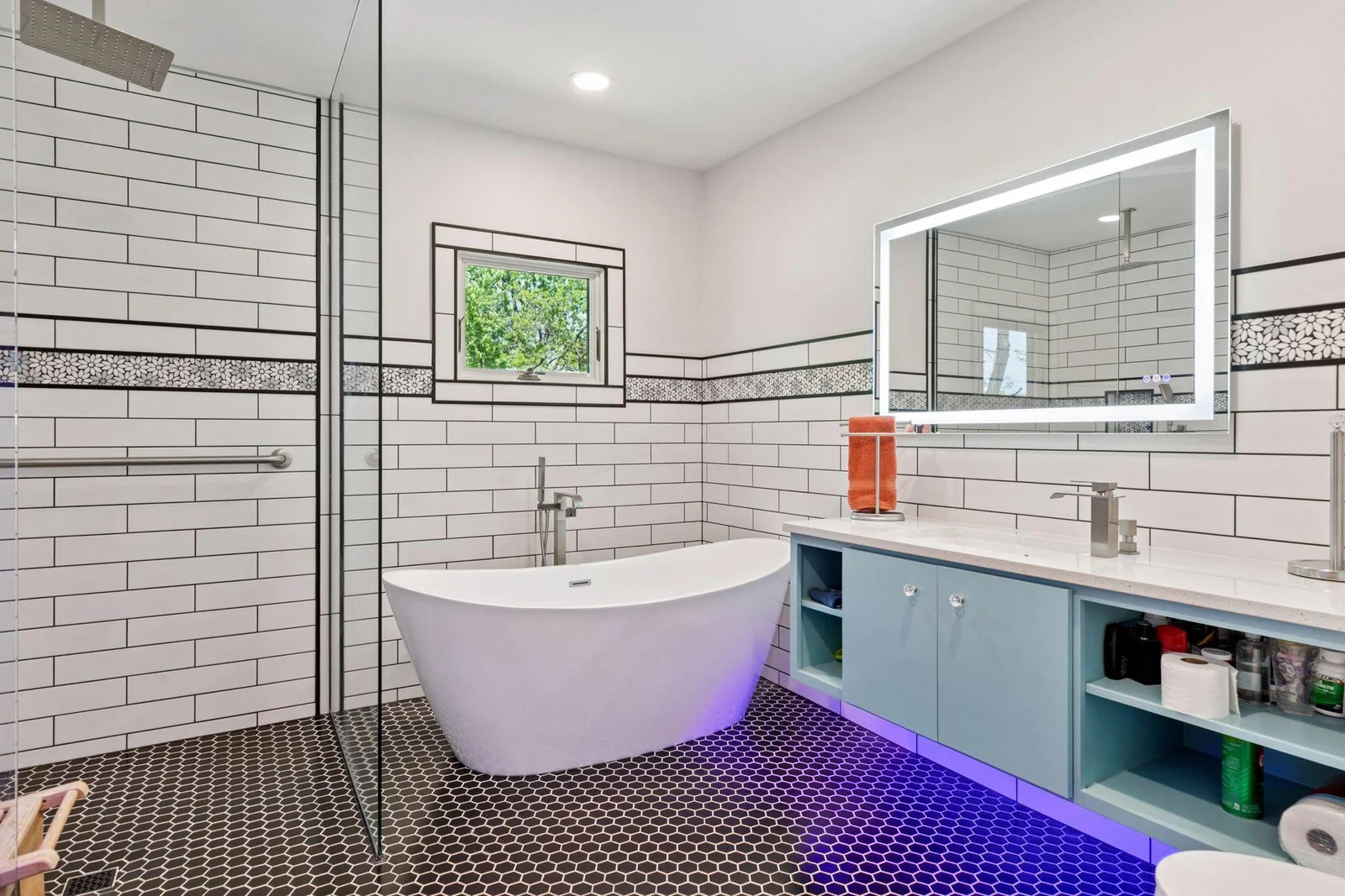 Flawlessly reimagined spa-inspired bath, featuring floating cabinetry, a soothing soaker tub, walk-in rainfall shower, a floating Toto toilet and even mood lighting!