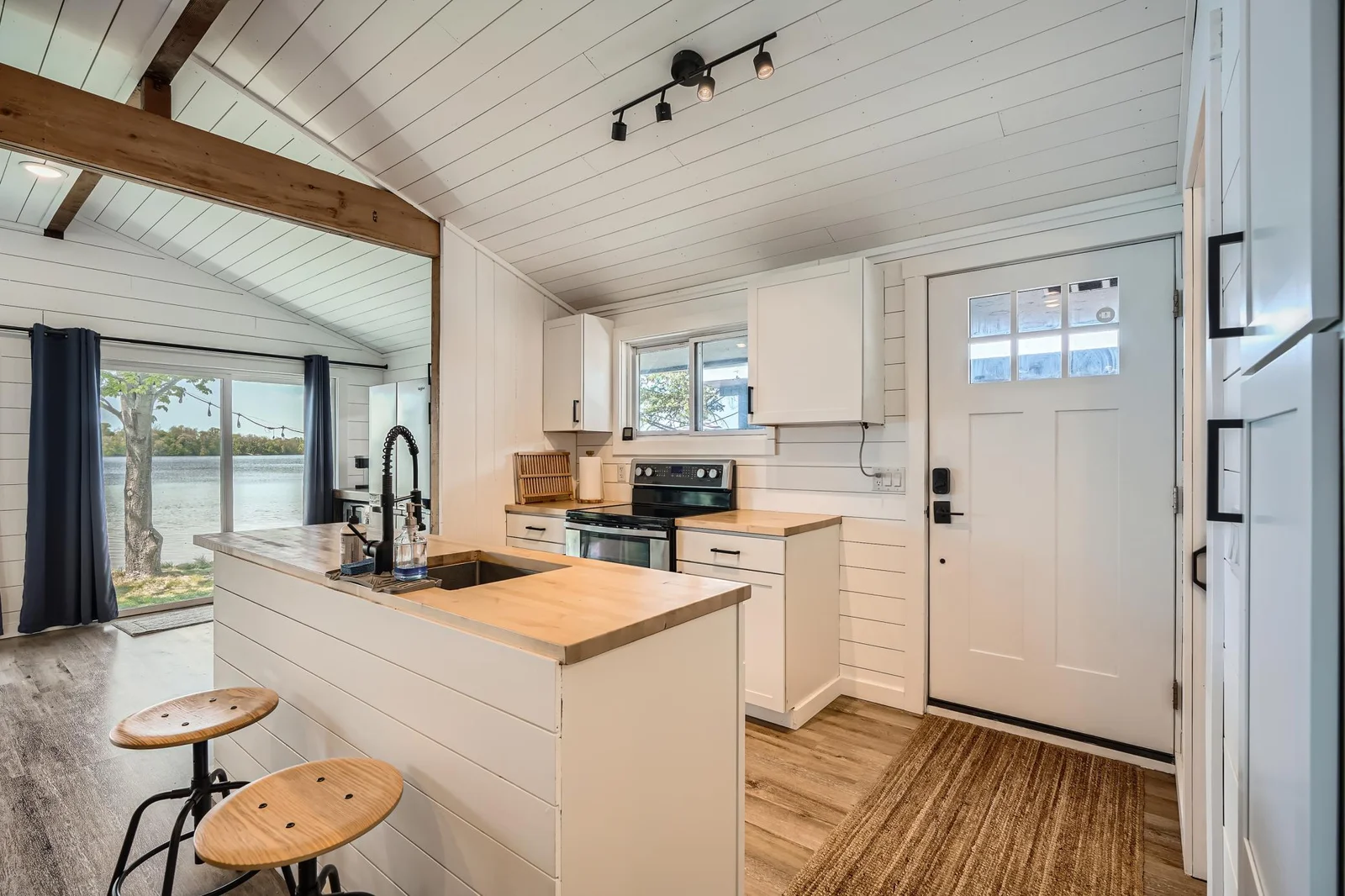 Kitchen greets you with vaulted ceilings, exposed beams, and sliding doors that frame lakefront views.