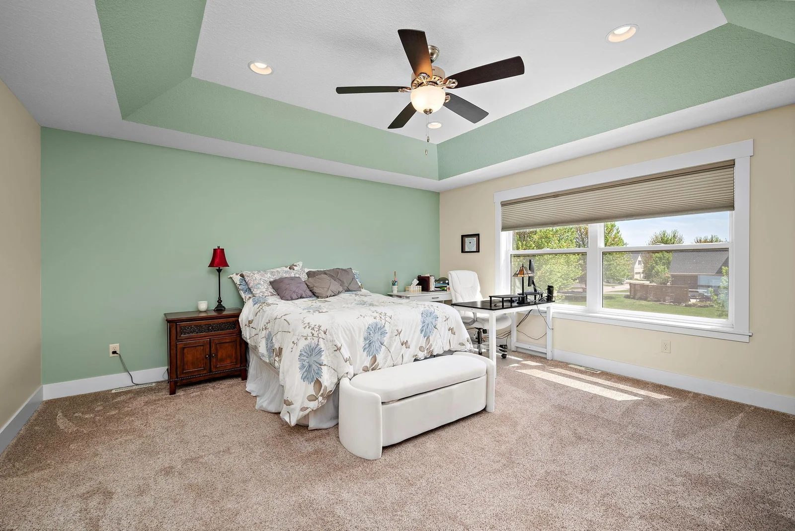 Large primary bedroom with tray ceiling