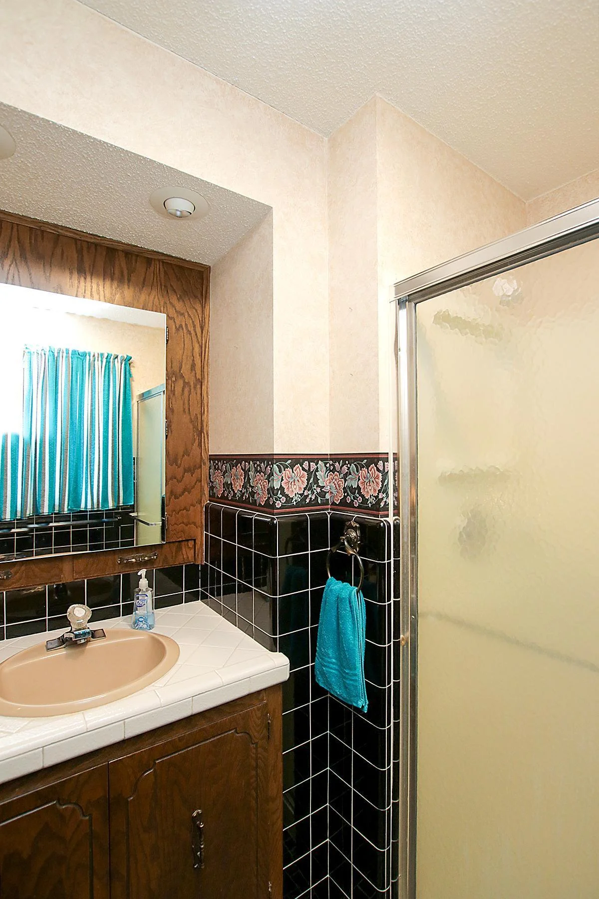 Main floor 3 piece bath wrapped with black tile! Be sure to check out the storage behind the mirror!