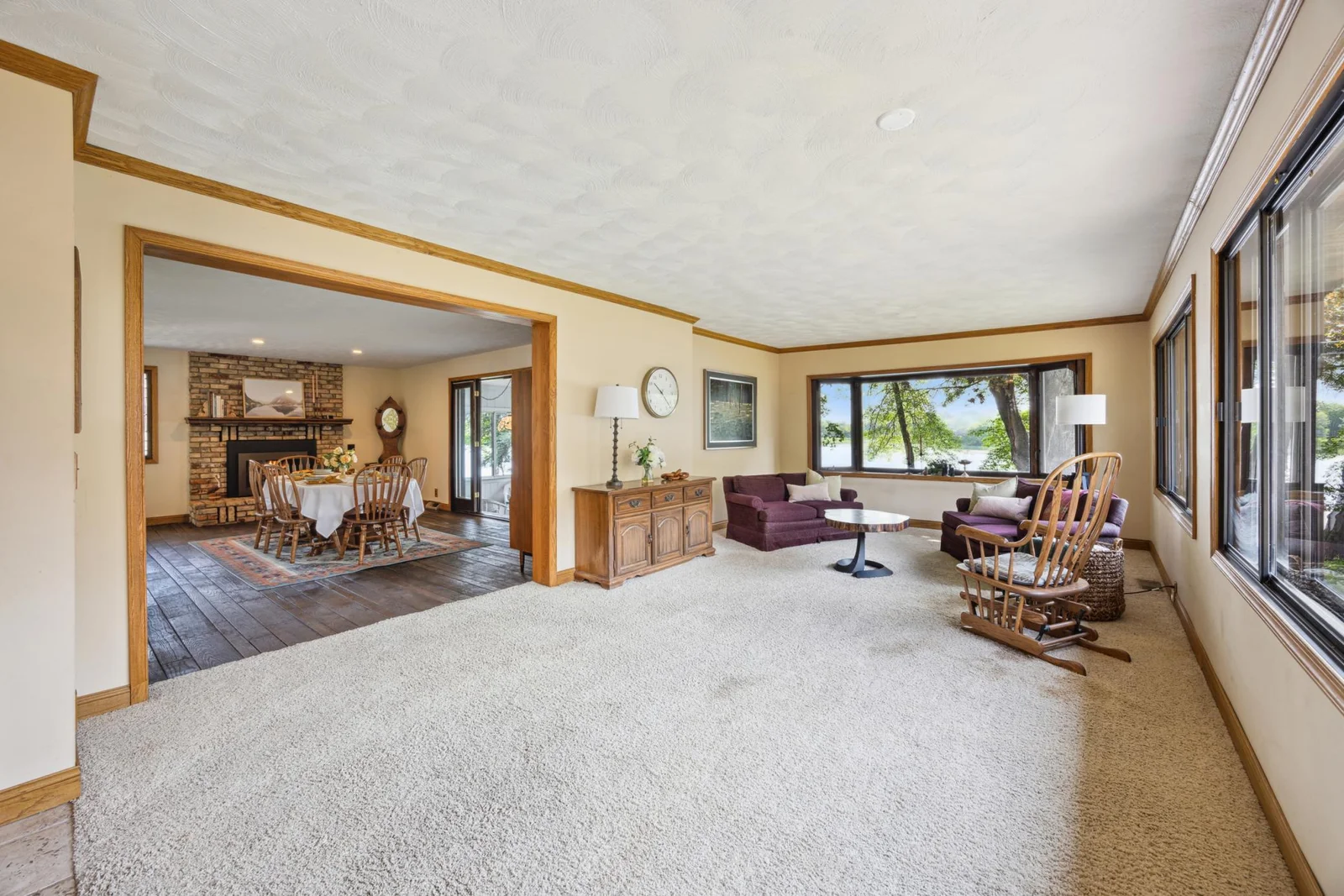 Another photof of the great room with windows with great views overlooking the lake. Into what is set up as the dining room.  Could be the family room with dining in the great room.
