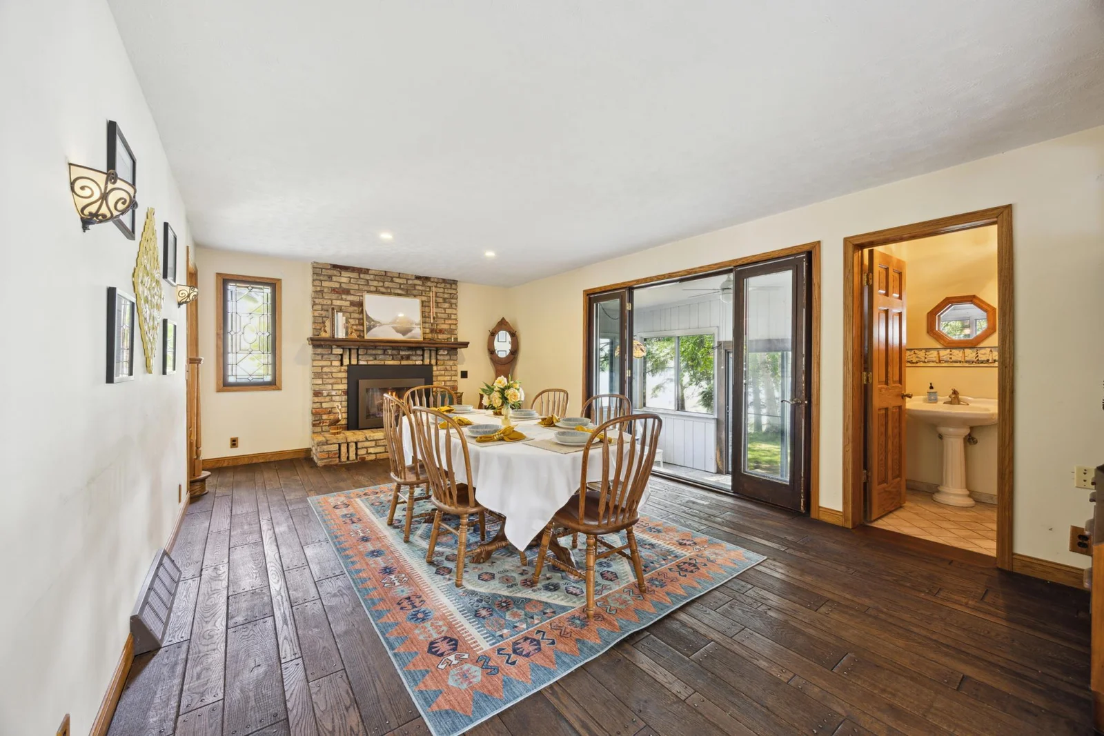 This is the dining room/ family room with a gas fireplace.  Leads to the 4 season porch also overlooking the lake. With half bath on the main level.