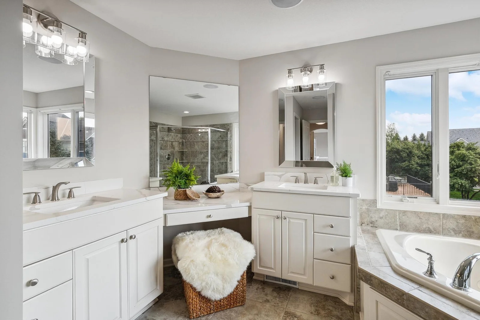 Bright and airy bathroom with a soaking tub and separate glass-enclosed shower.