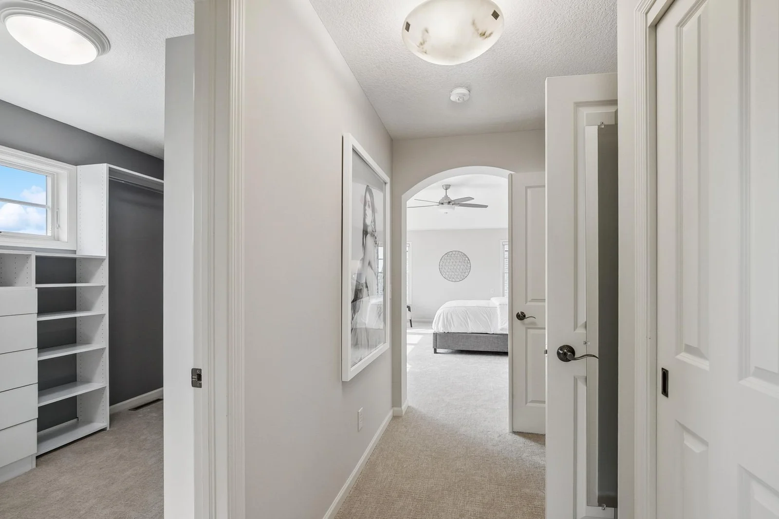 Elegant entryway sets the tone for the spacious and serene primary suite beyond.