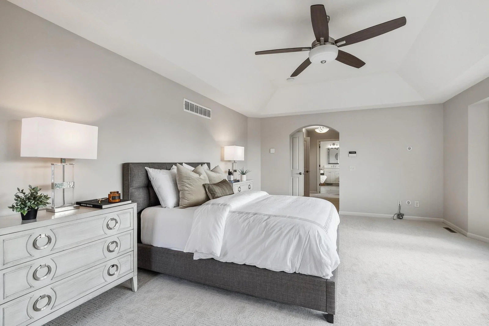 Primary bedroom features plush carpeting and elegant finishes throughout.