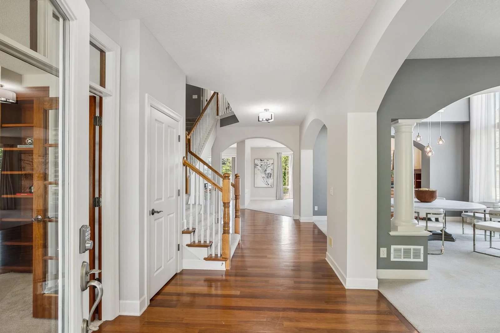 A welcoming entryway bathed in natural light—warm cherry wood floors set the tone for the entire home.