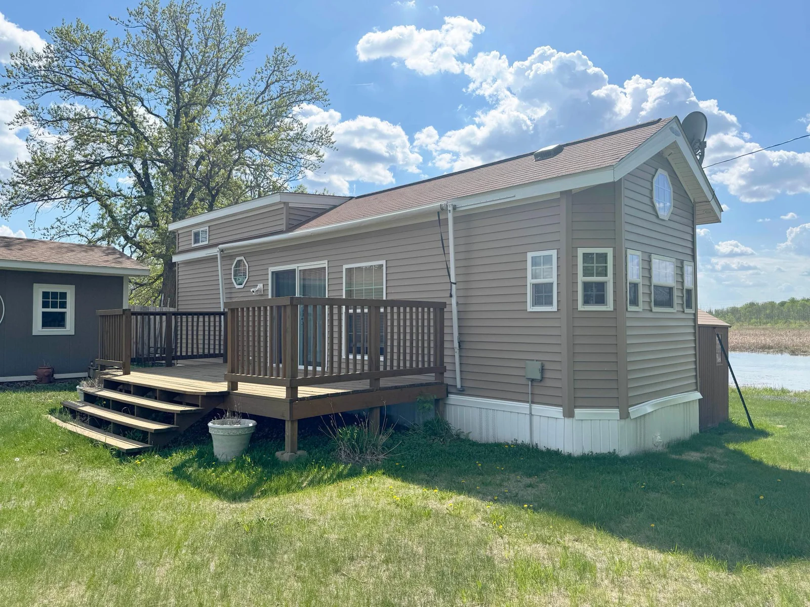 Another angle of park model exterior. This 11x36 seasonal park model includes ample main floor living space, a main floor bedroom plus upper level loft sleeping and den space!
