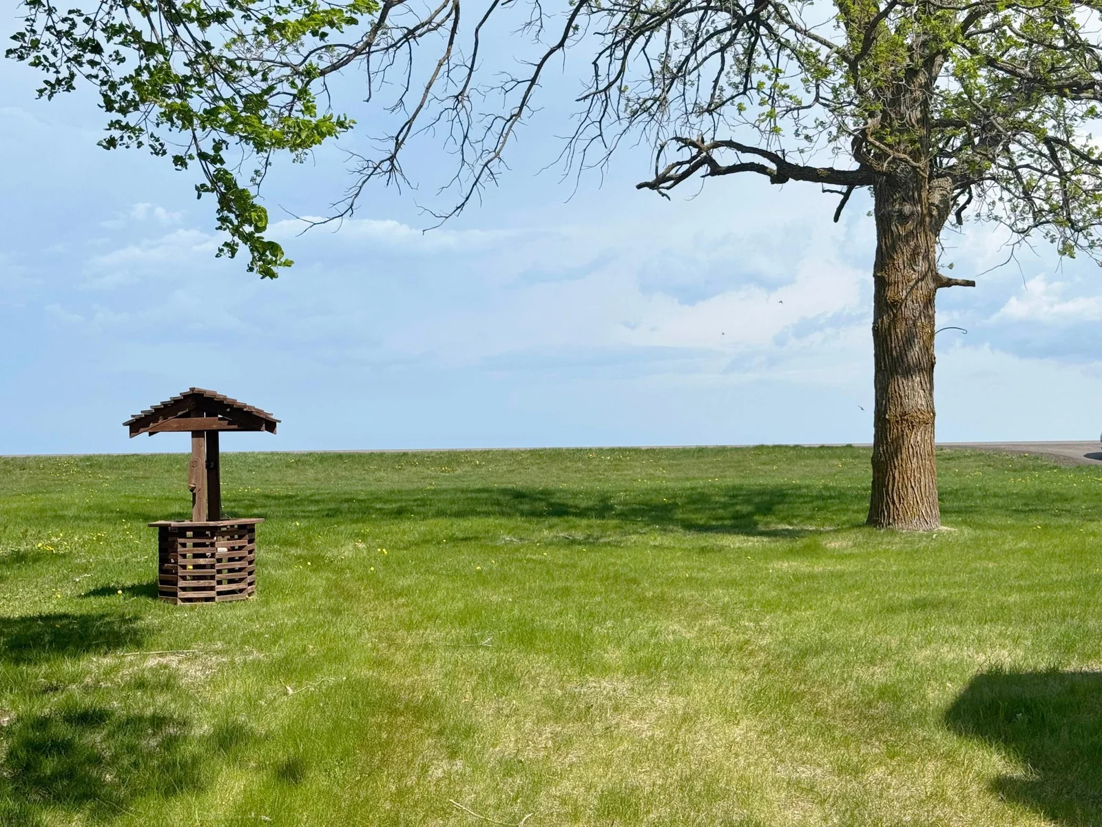 Looking across the front yard towards the highway and the lake...clear blue sky and sparking water views as far as the eye can see looking across the lake!