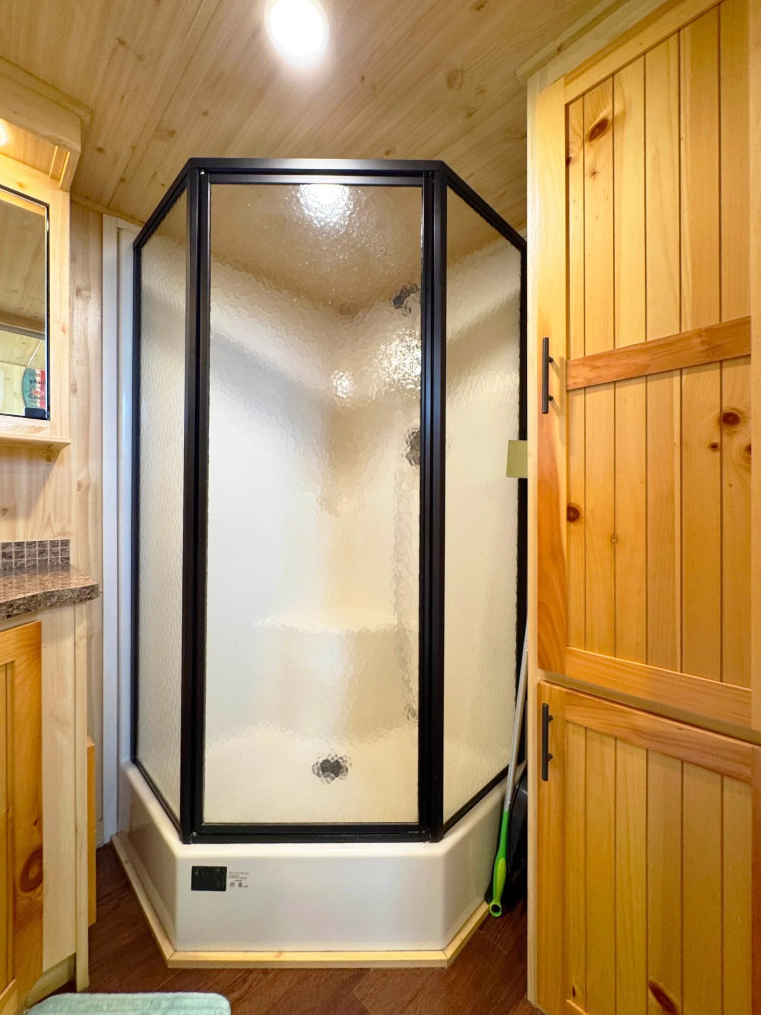 Another angle of the bathroom featuring the shower and storage cabinets.