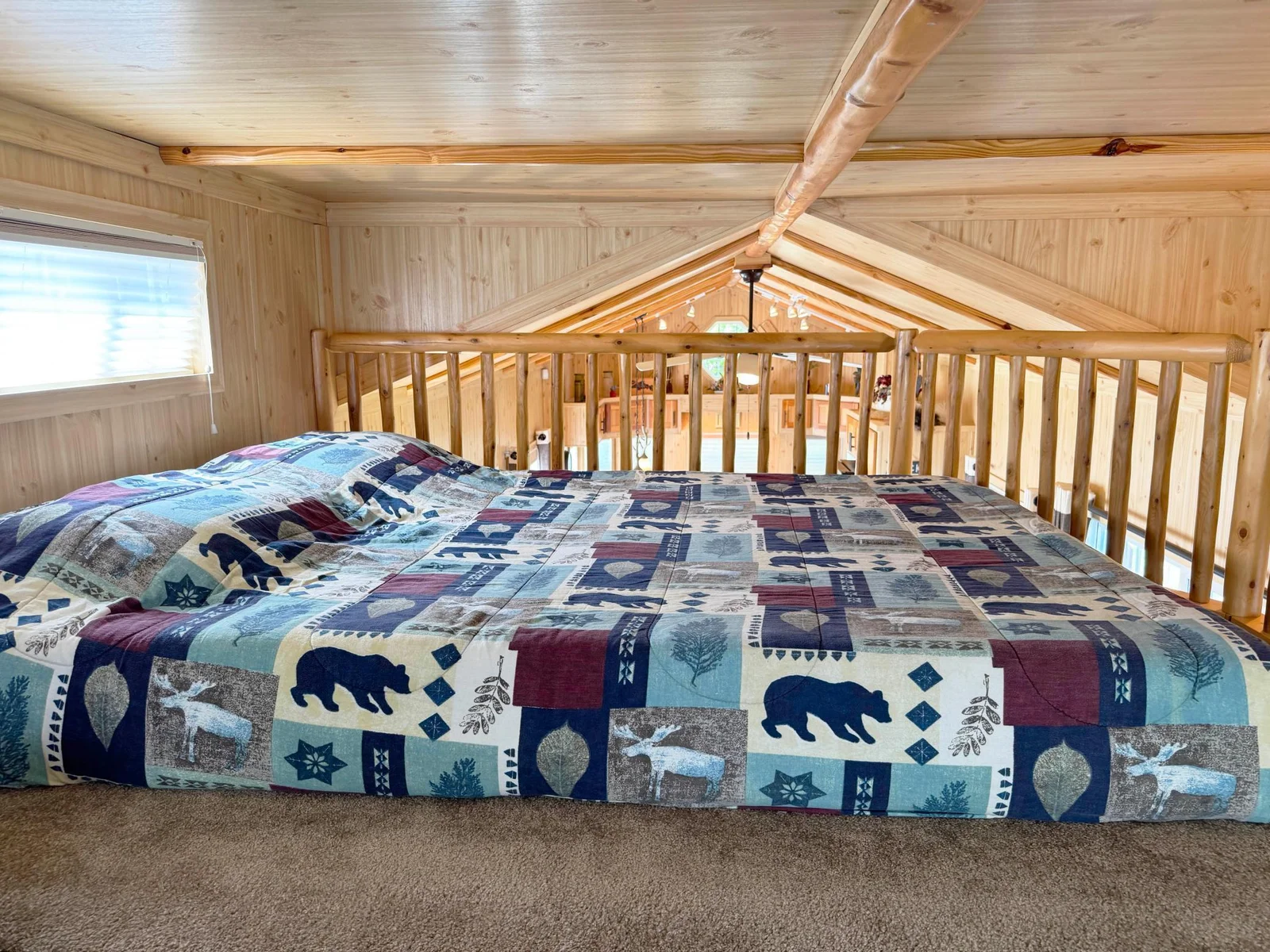 One more look at the bed in the loft with the living room and kitchen beyond the bannister.