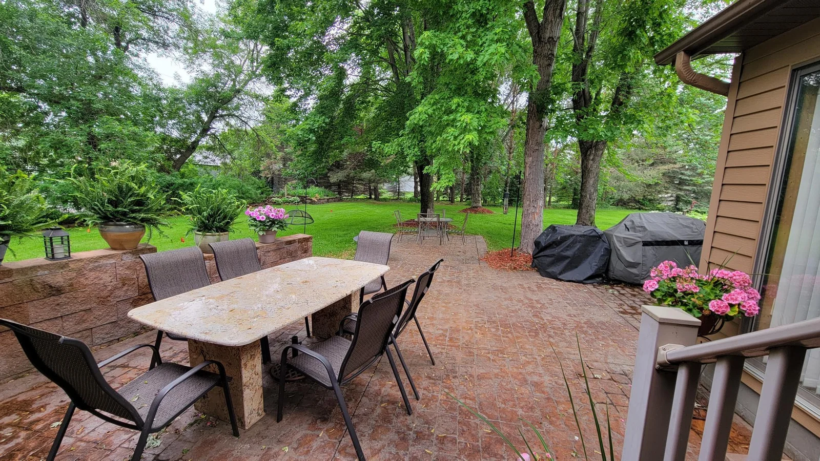 Secluded stamped concrete patio in the backyard, off of the kitchen + sunroom. Solid granite table stays with home