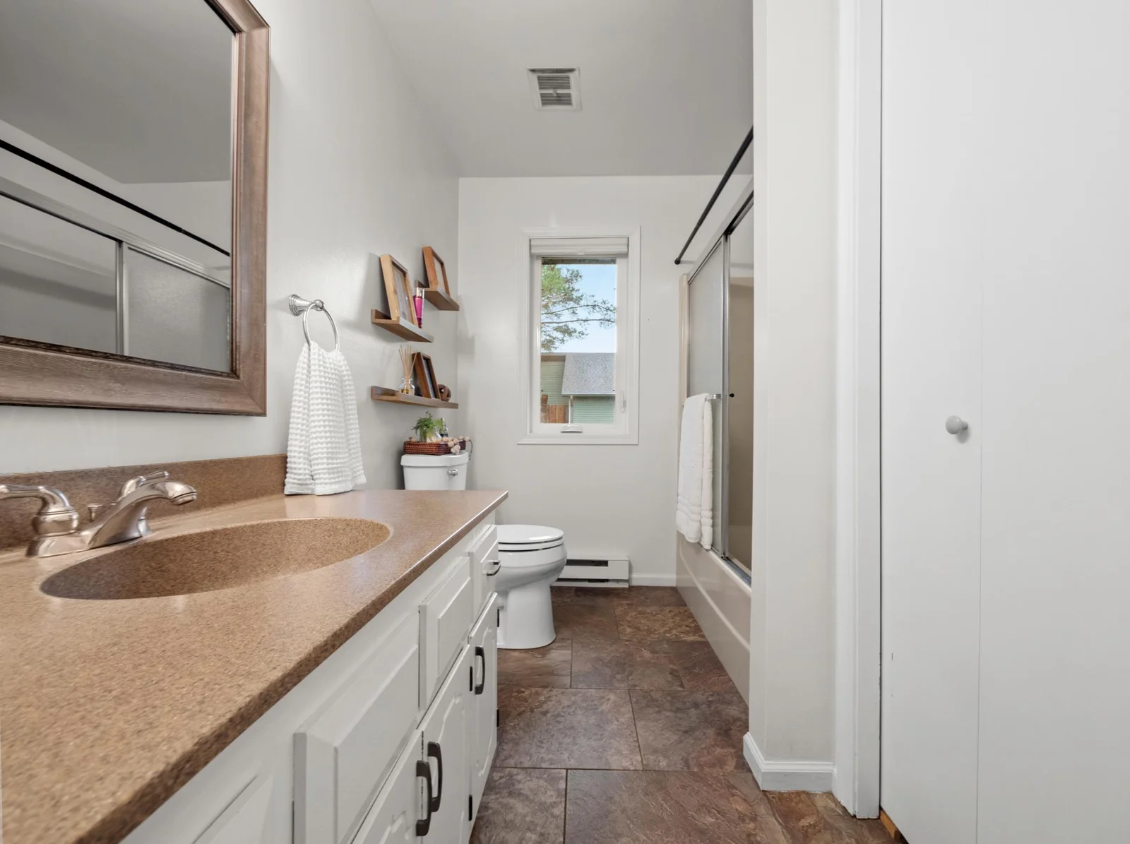 The upper level full bath features a crisp white vanity and a spacious layout, making morning routines a breeze.