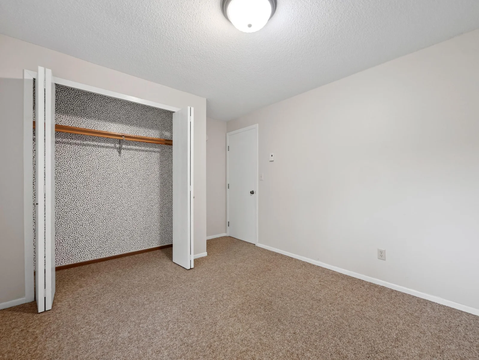 The lower level bedroom offers plush carpet and neutral colors.