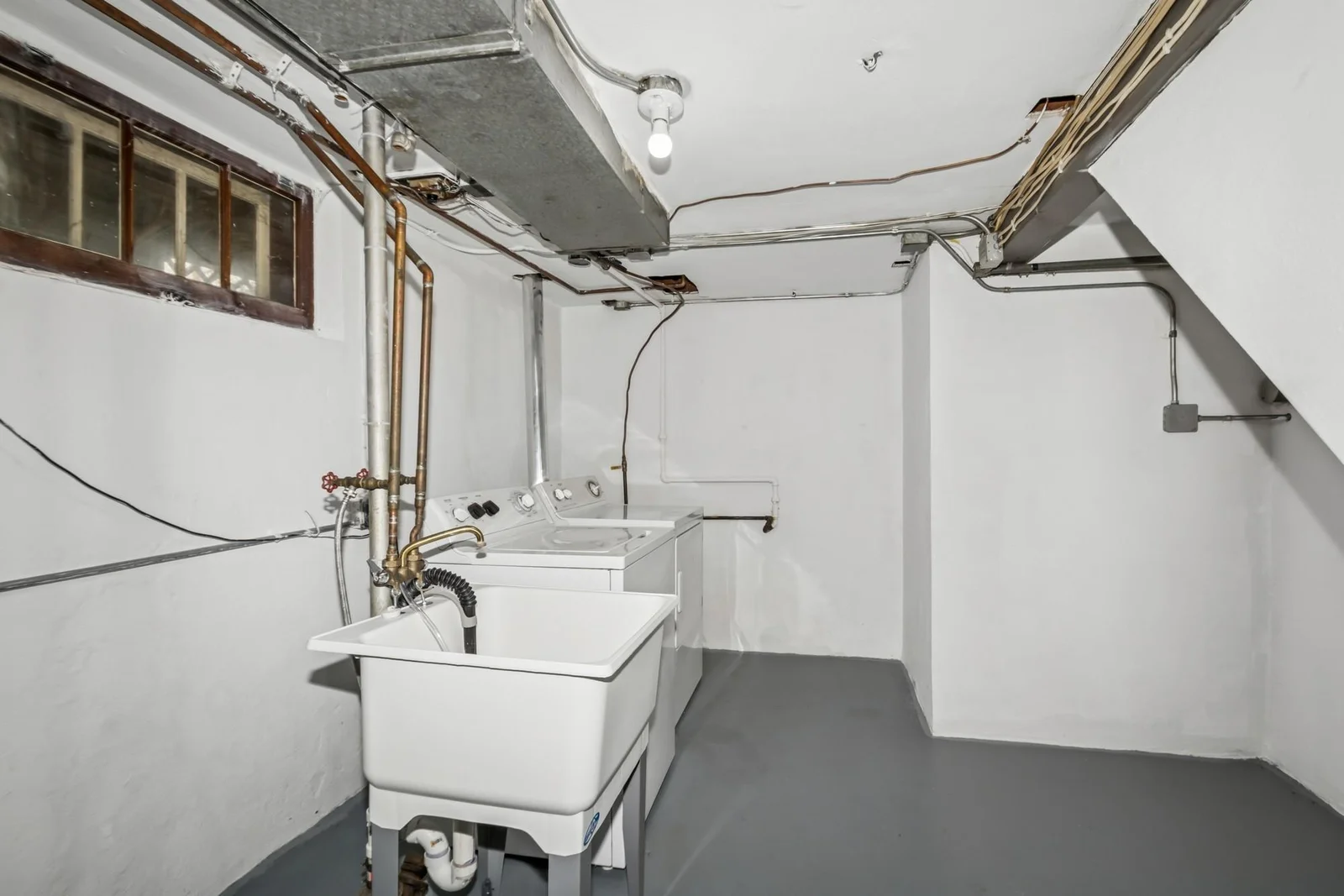 Large laundry room space with utility sink.