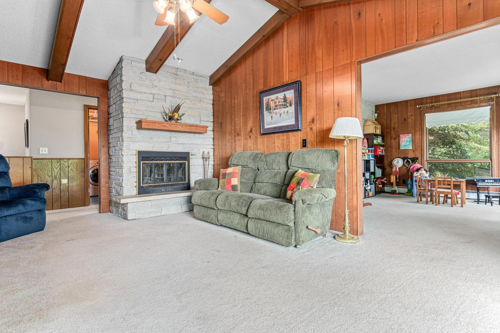Soaring vaults, wood beams and a gorgeous stone fireplace are just a few of the lovely features you will find throughout the home that showcase the mid-century style.