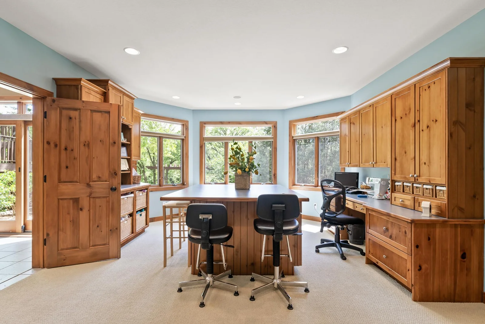 This hobby room is a dream!  lots of work space, storage and a view!