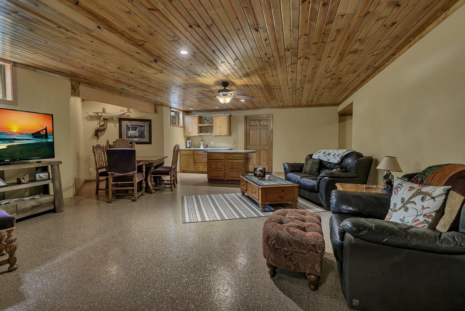 Lower level family room is large and offers epoxy floors, knotty pine ceiling, lookout windows and wet bar area.