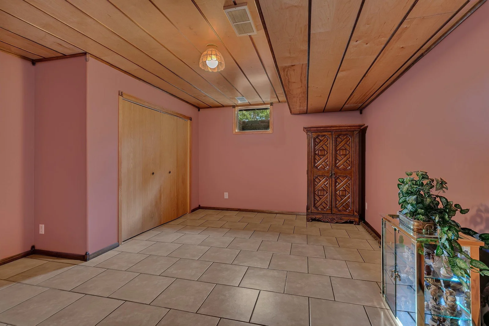 Lower level 4th non-conforming bedroom just needs an egress windows. This room offers a large closet, wood ceiling, & tile floors.
