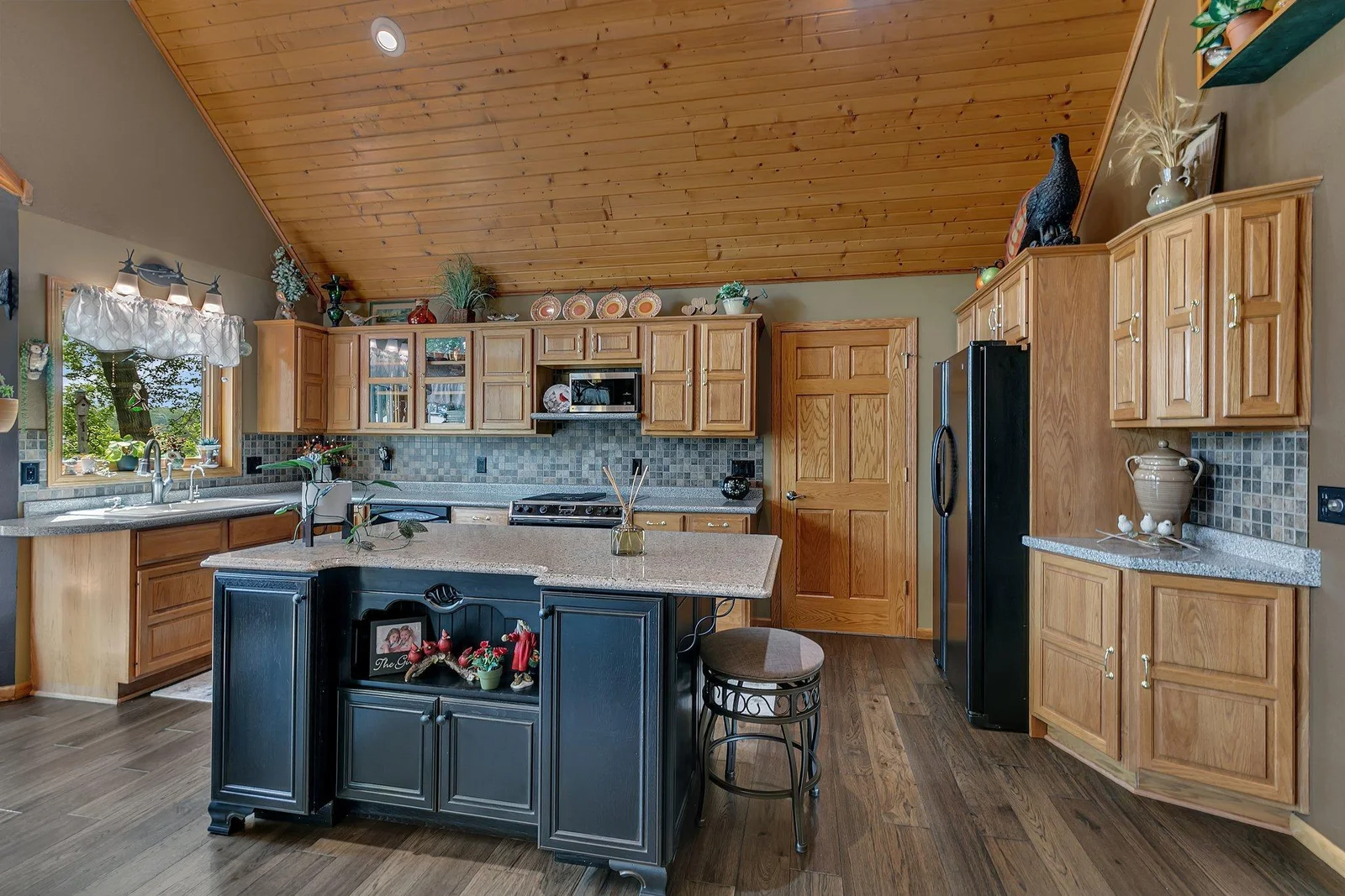 This gourmet kitchen is ready for you to enjoy meal prep and entertaining. Large open space with vaulted ceilings, large windows allowing for lakeviews and access the the paver patio for grilling.