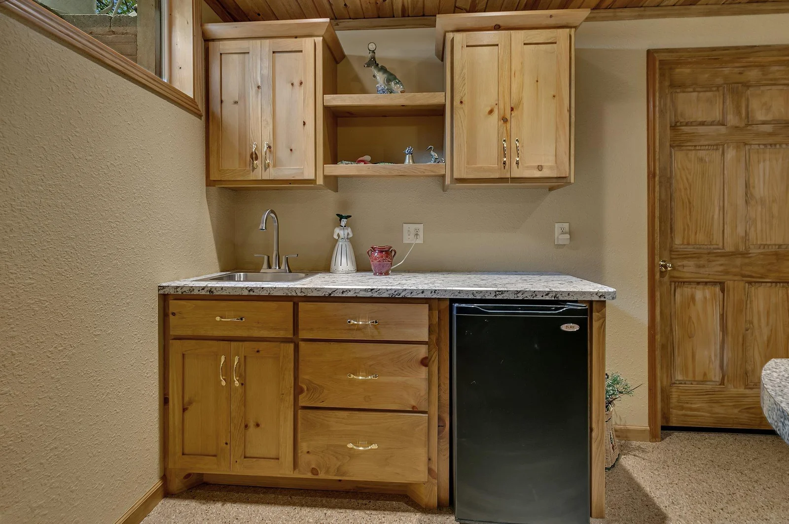 Lower level wet bar area with fridge and ample storage is great for game-day gatherings.