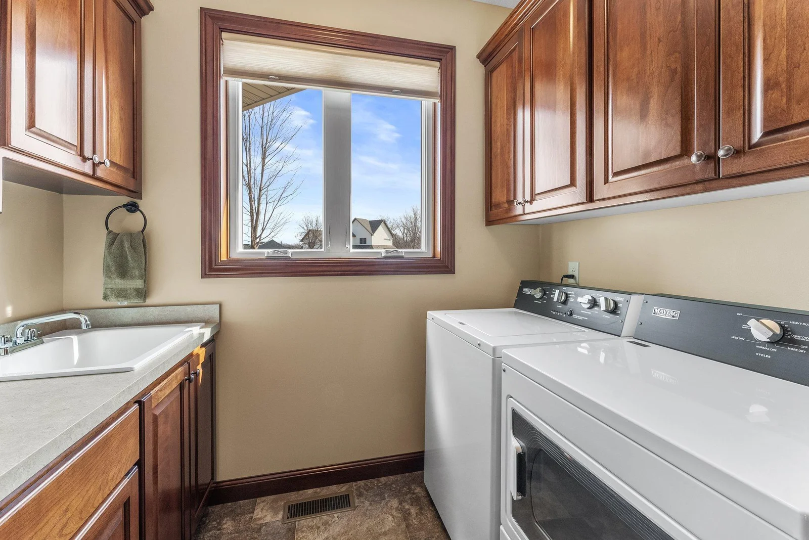 The laundry room off the mudroom area is a practical space with plenty of space for storage and includes a laundry sink.