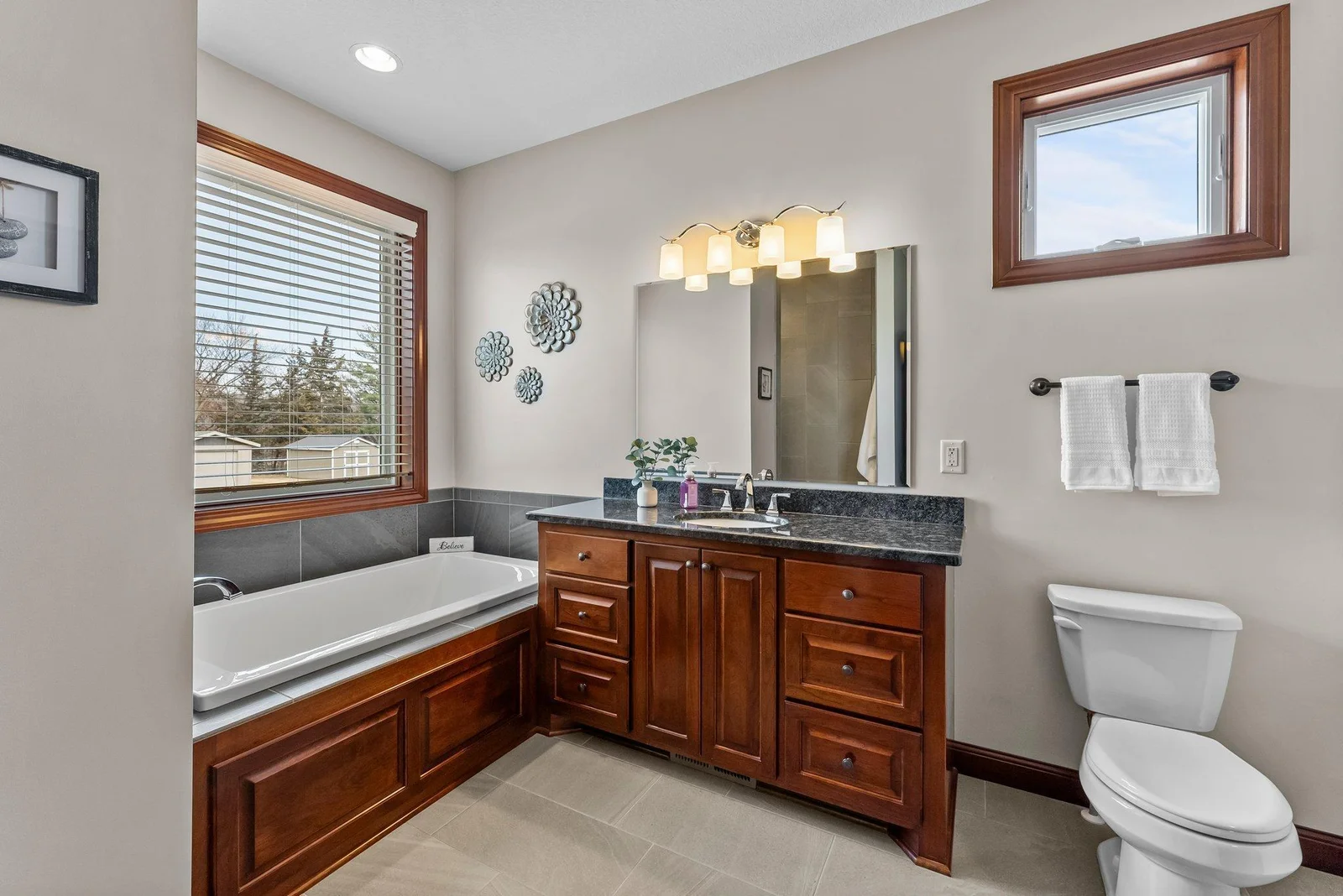 The ensuite bathroom is a spa-like oasis, featuring a large walk-in tiled shower and a soaker tub for relaxation.