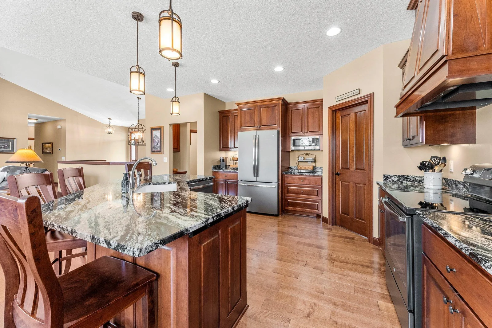 The gourmet kitchen features stunning granite countertops, rich cherry wood cabinets, and a generously sized center island that provides both workspace and seating.