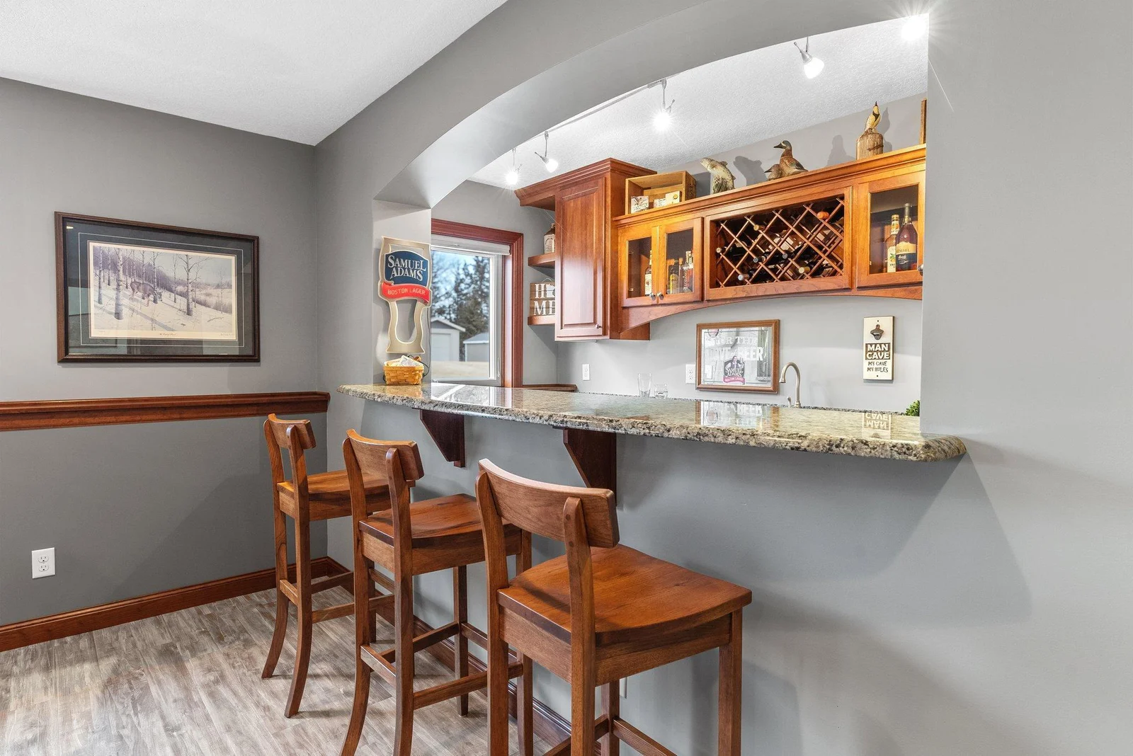 An adjacent wet bar, with granite countertops and a beverage fridge, adds an extra touch of sophistication to this already impressive space.
