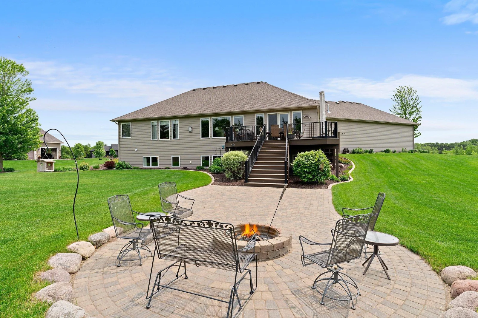Outside, the large paver patio, complete with a firepit, offers a perfect place to unwind and enjoy the outdoors.