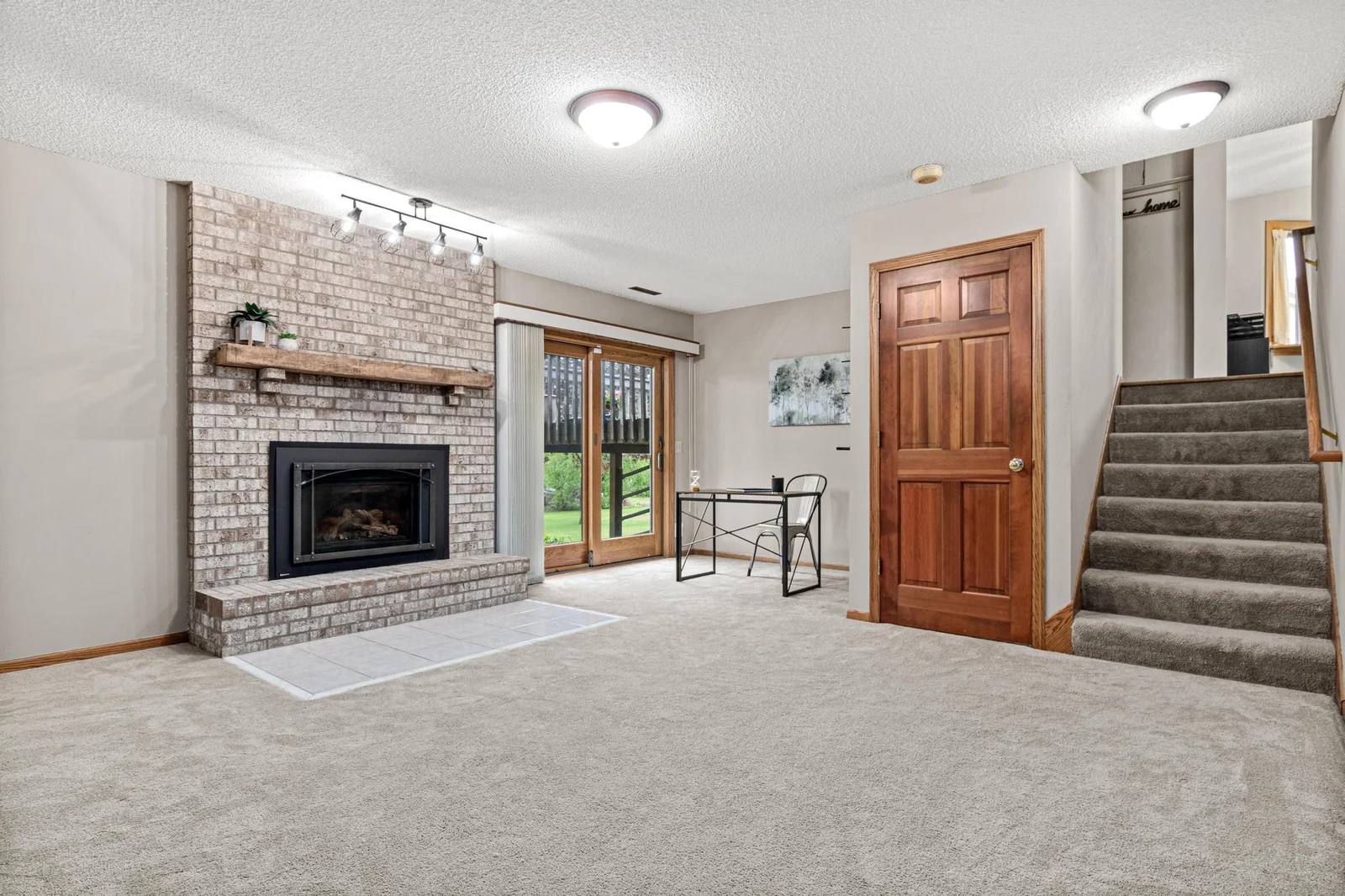 Cozy gas fireplace and walkout that leads to the concrete patio