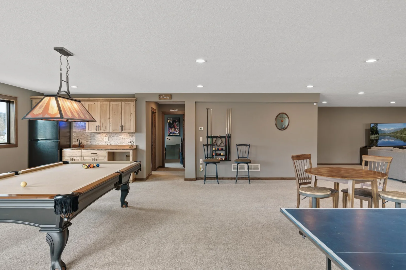 Take a break from the action and grab a beverage or snack from your wet bar with with custom hickory cabinets and stunning black walnut, live edge counter top.