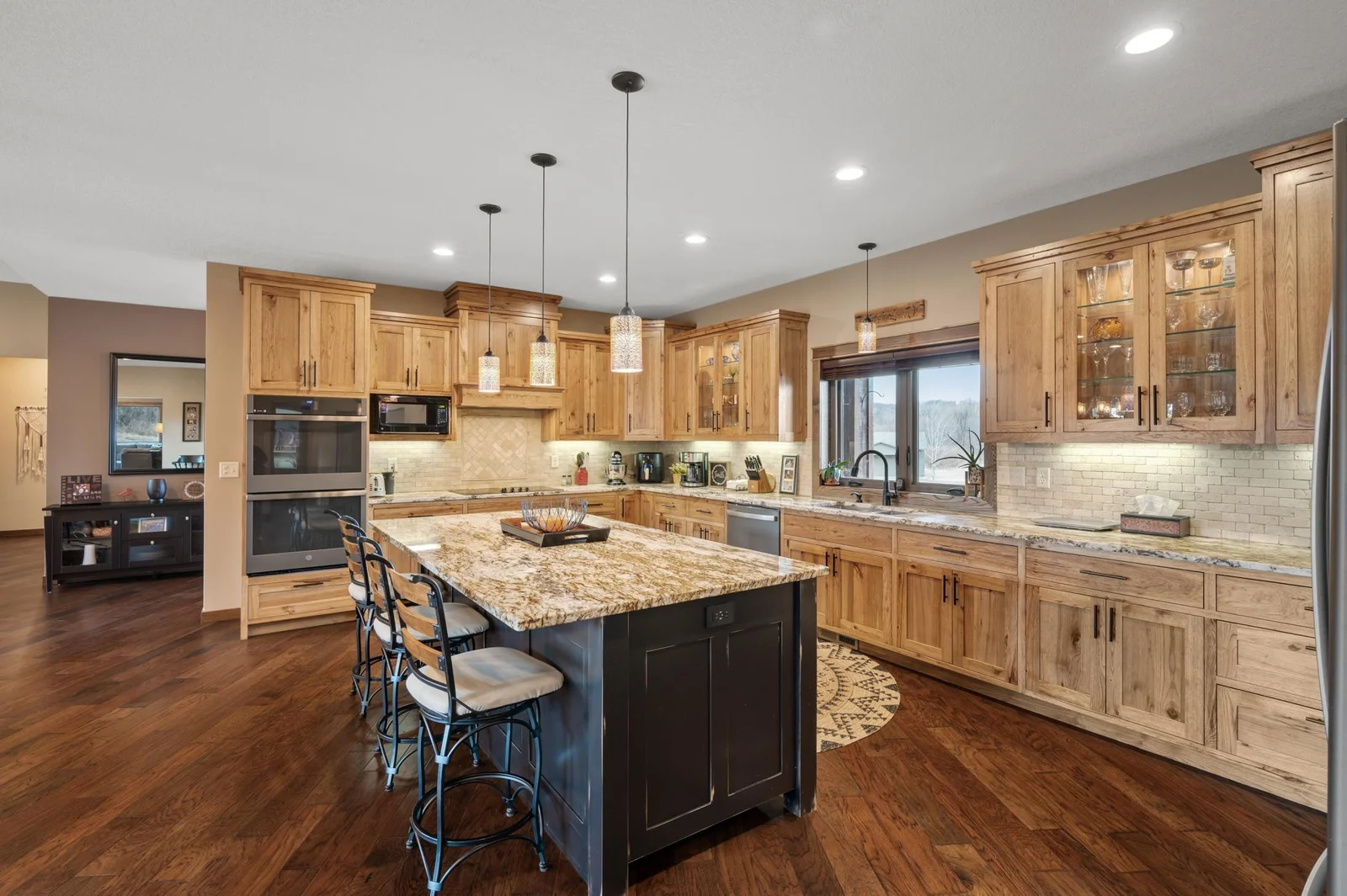Your gourmet kitchen is a culinary masterpiece featuring beautiful custom hickory cabinetry, massive center island, double oven, and a separate cooktop.