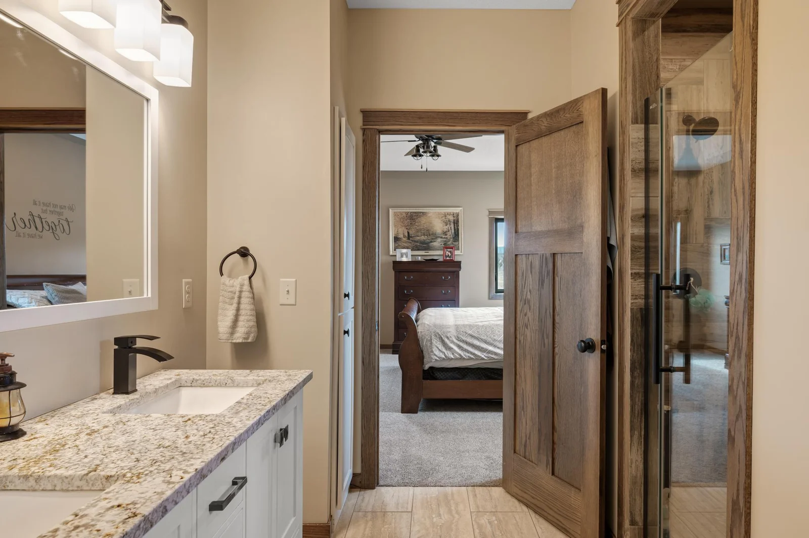 The highlight of this bathroom is the oversized 6x4 shower with a stunning glass door, tile surrounds, and black hardware. The perfect mix of modern and rustic design with the natural wood trim.