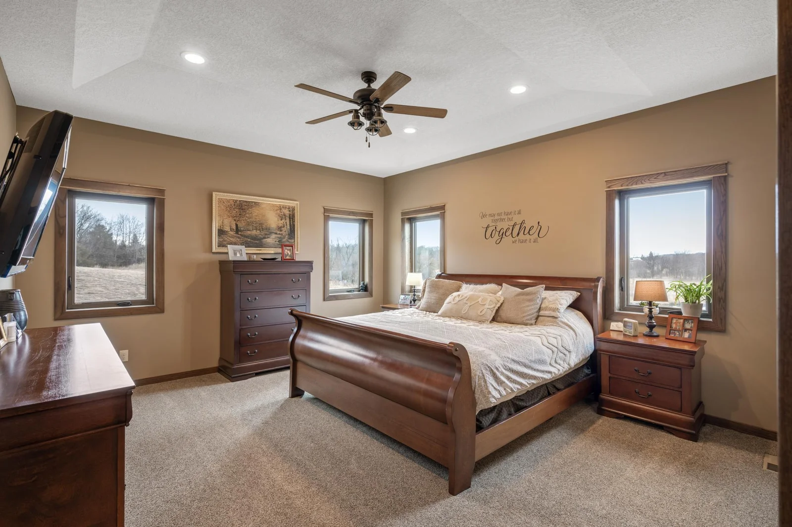 Welcome to your main level primary suite retreat! Vaulted tray ceilings create an elegant and luxurious feel right when you walk in. The 4 large windows around the room let in a ton of natural light.