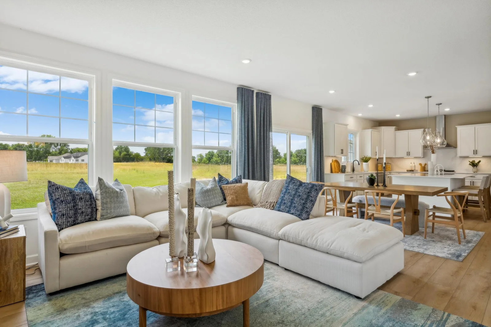 Photo is of the actual model. The spacious great room seamlessly connects to the kitchen area, perfect for entertaining. It also features many large windows providing warm natural light.