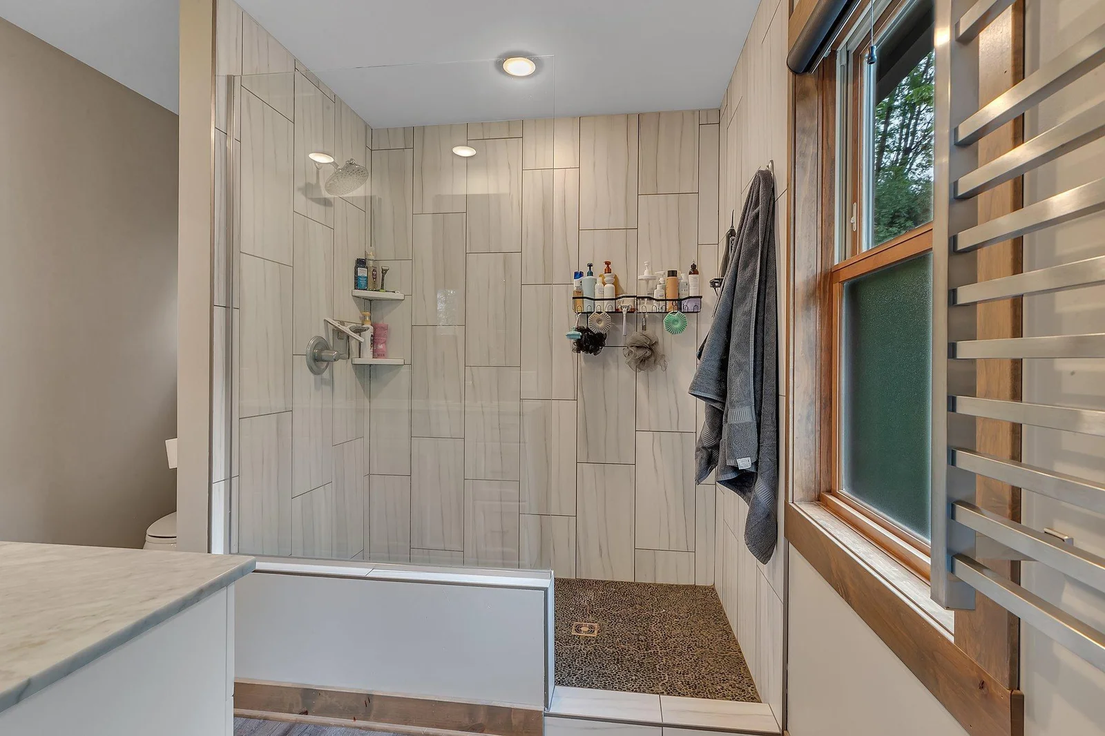 Spa-like bathroom includes a custom tile shower with modern design touches.