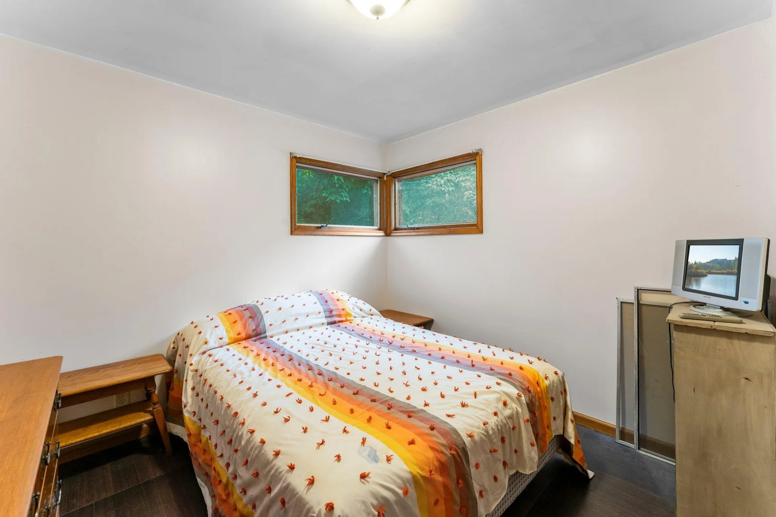 A well-sized bedroom offers stylish flooring and closet storage.