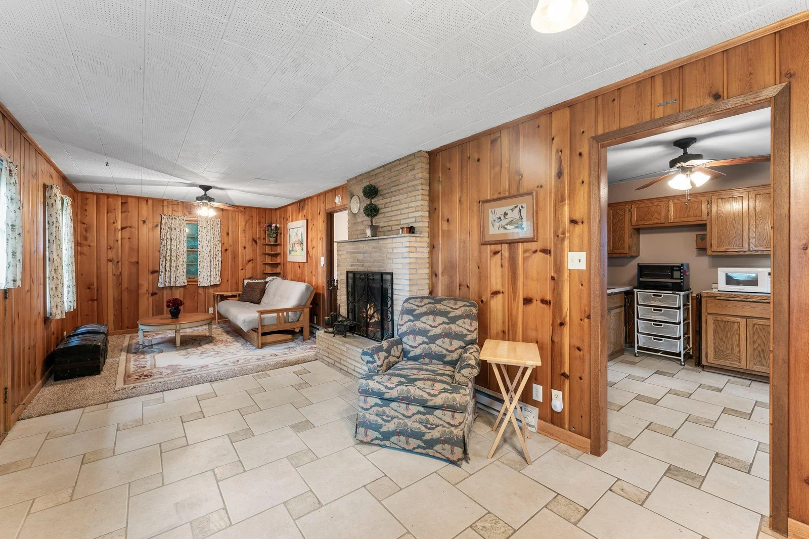 Step into a bright dining area with built-in china cabinets, tile flooring, and wood-paneled walls.