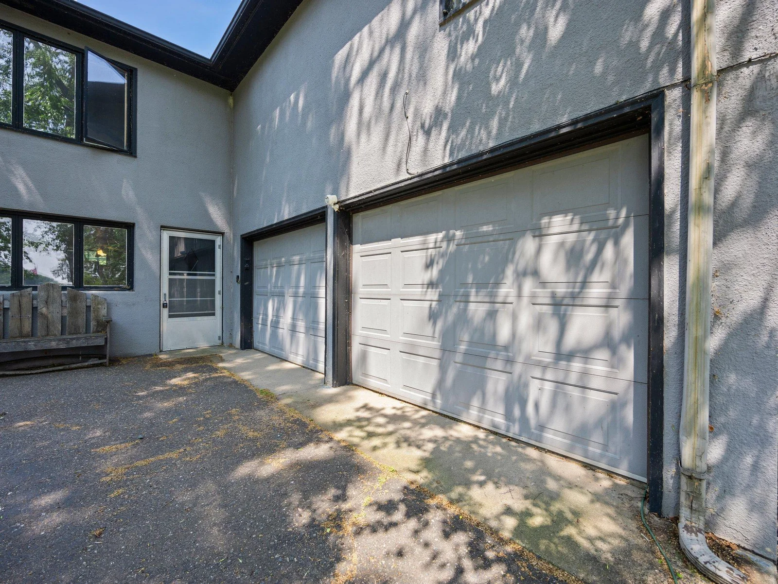 From here, access the attached two-car garage, which includes built-in shelving, a workbench area, and a remote-controlled opener.