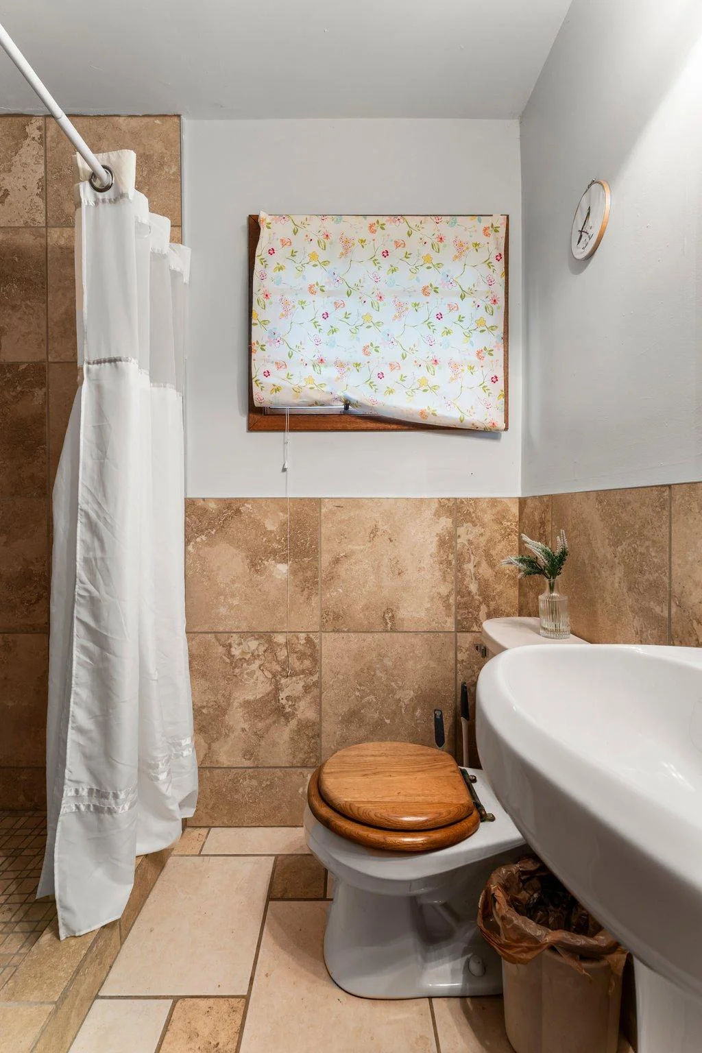 The ¾ bathroom features tiled flooring and wainscoting. There’s also a hallway with space for a stackable washer and dryer—offering added convenience for guests or tenants.