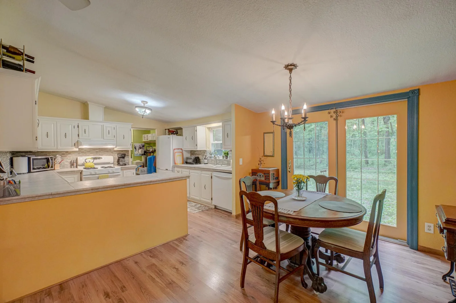 Enjoy meals or entertain with ease in the inviting dining area, where expansive windows showcase the serene beauty of the surrounding nature