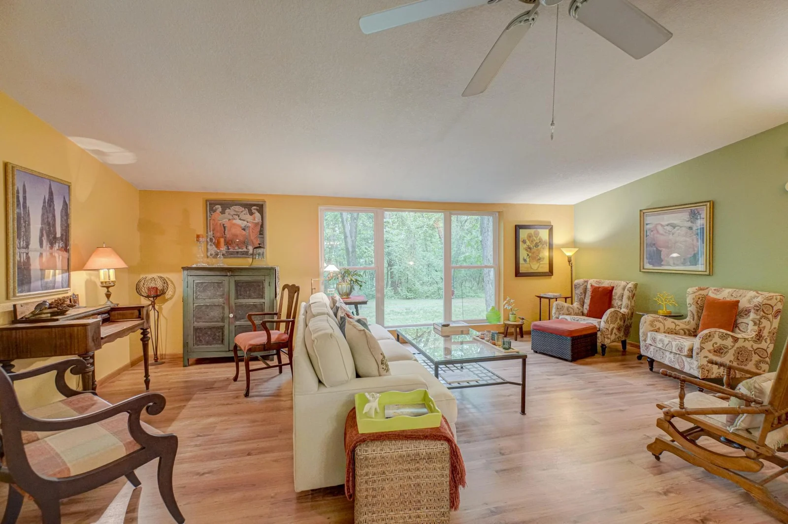 A bright and spacious main-level living room welcomes you with floor-to-ceiling windows that flood the space with natural light and frame peaceful views of the surrounding landscape