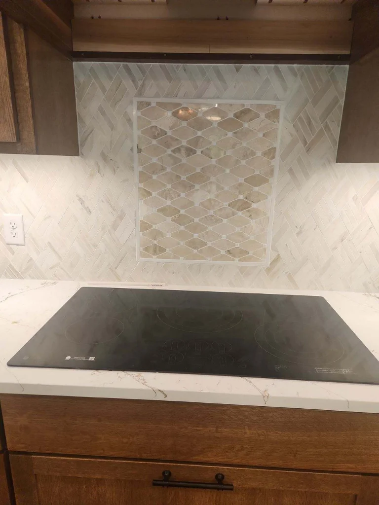 Your custom designed tile backsplash features an intricate inlay above the cooktop!